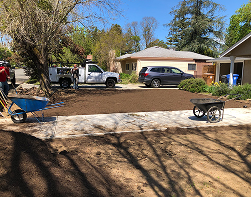 Hills of top soil waiting for the right side of the walkway